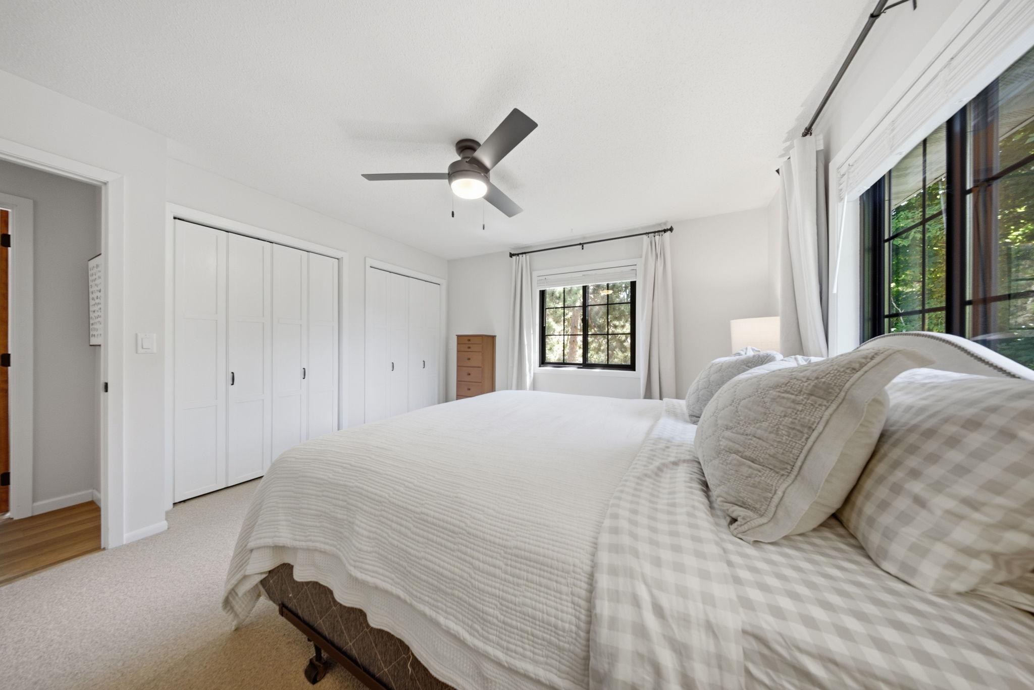 Primary bedroom offers generous closet space and peaceful neighborhood views.