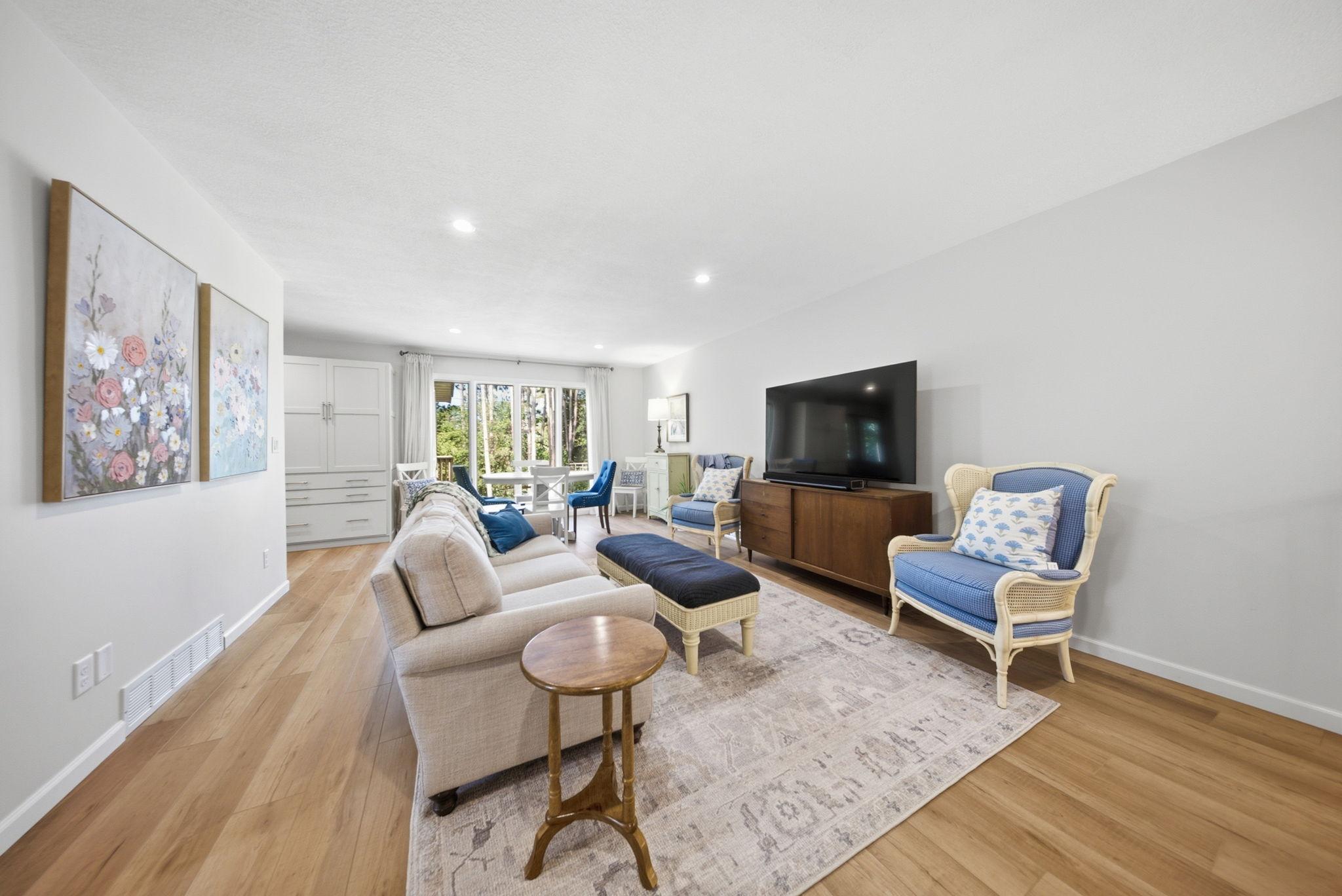 Bright, inviting living room with updated flooring and abundant natural light