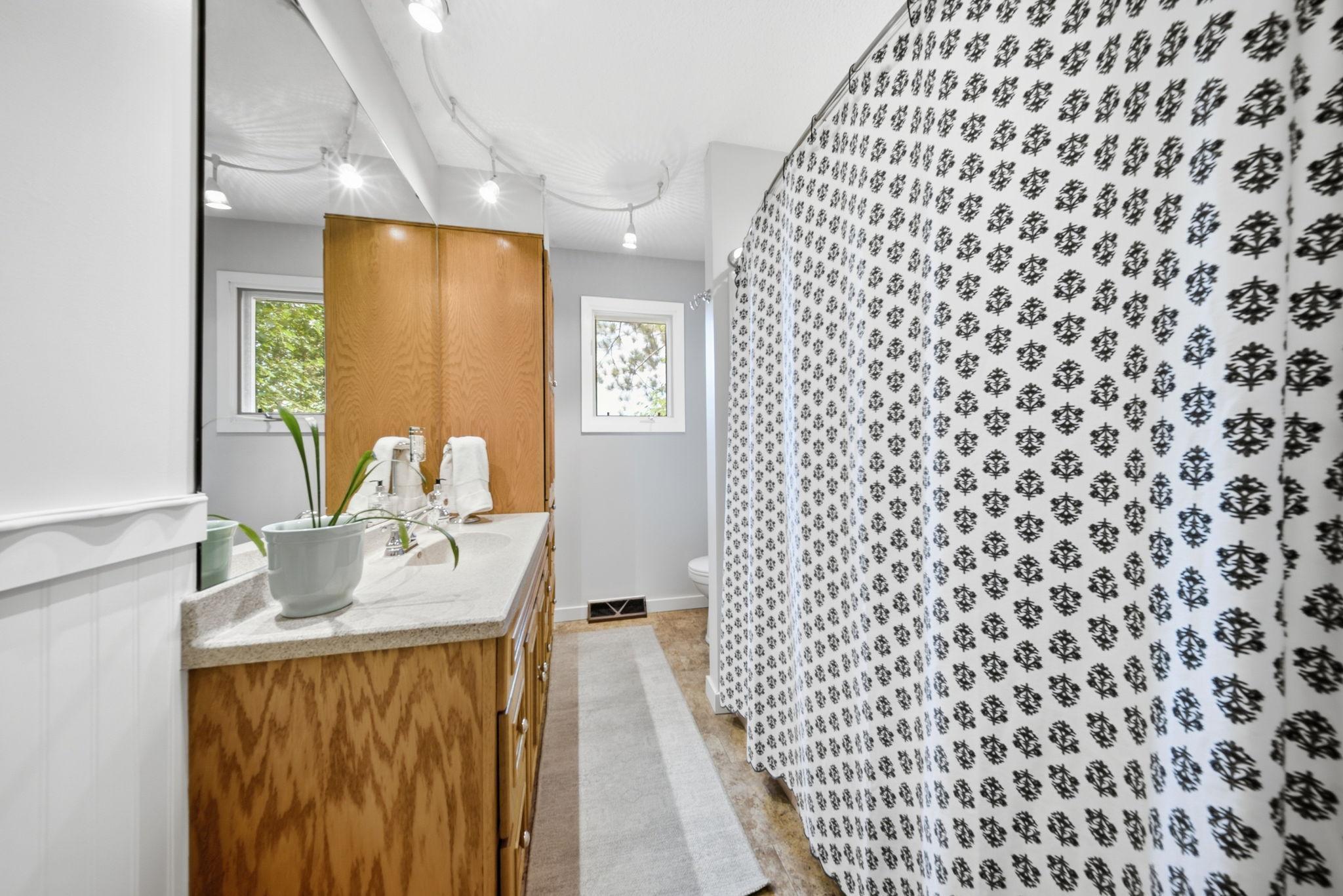 Main-level full bath with oversized vanity and window for natural light.