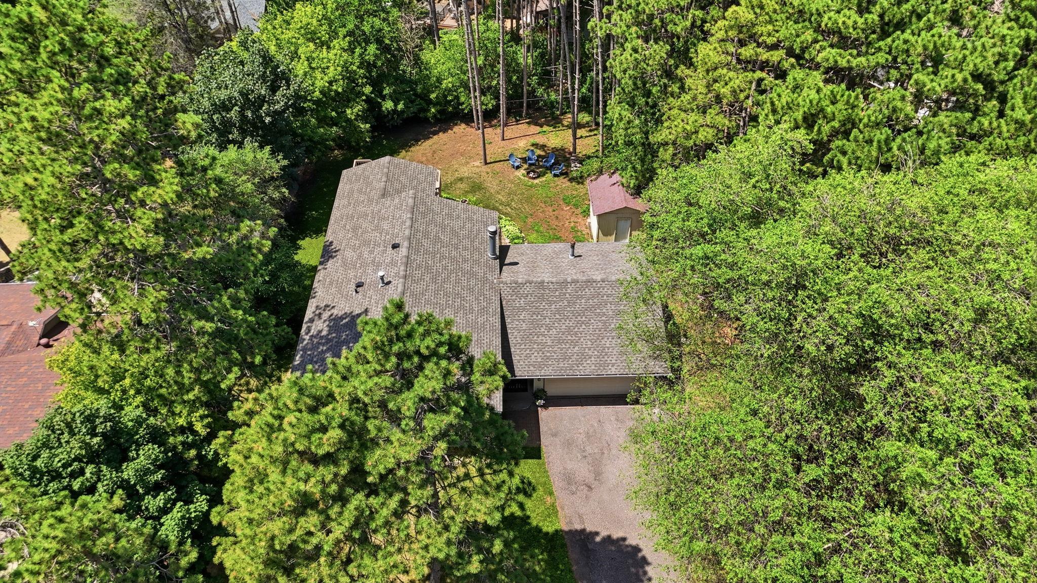 Aerial view showcasing the home's mature tree canopy and private backyard setting.