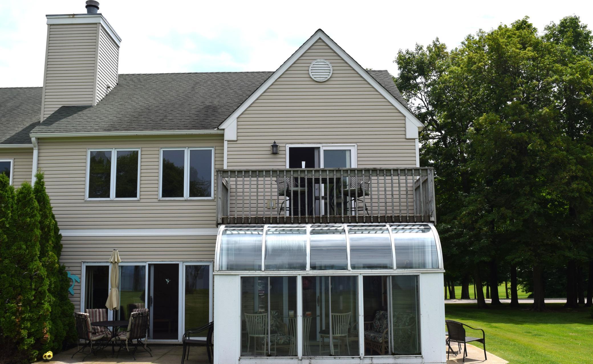 Rear view with sunroom, patio and deck.