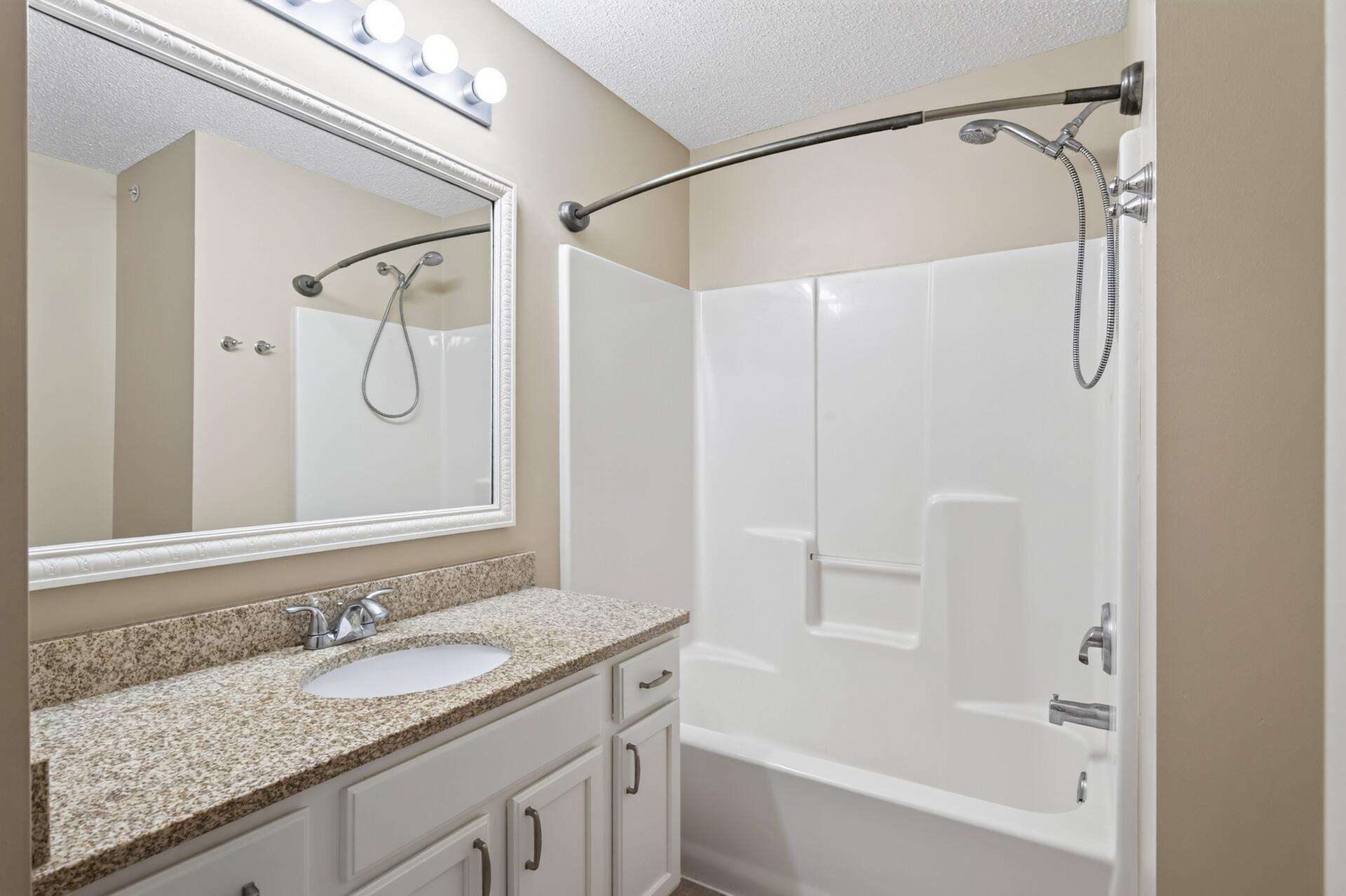 Beautifully updated full bathroom with granite vanity and timeless finishes.