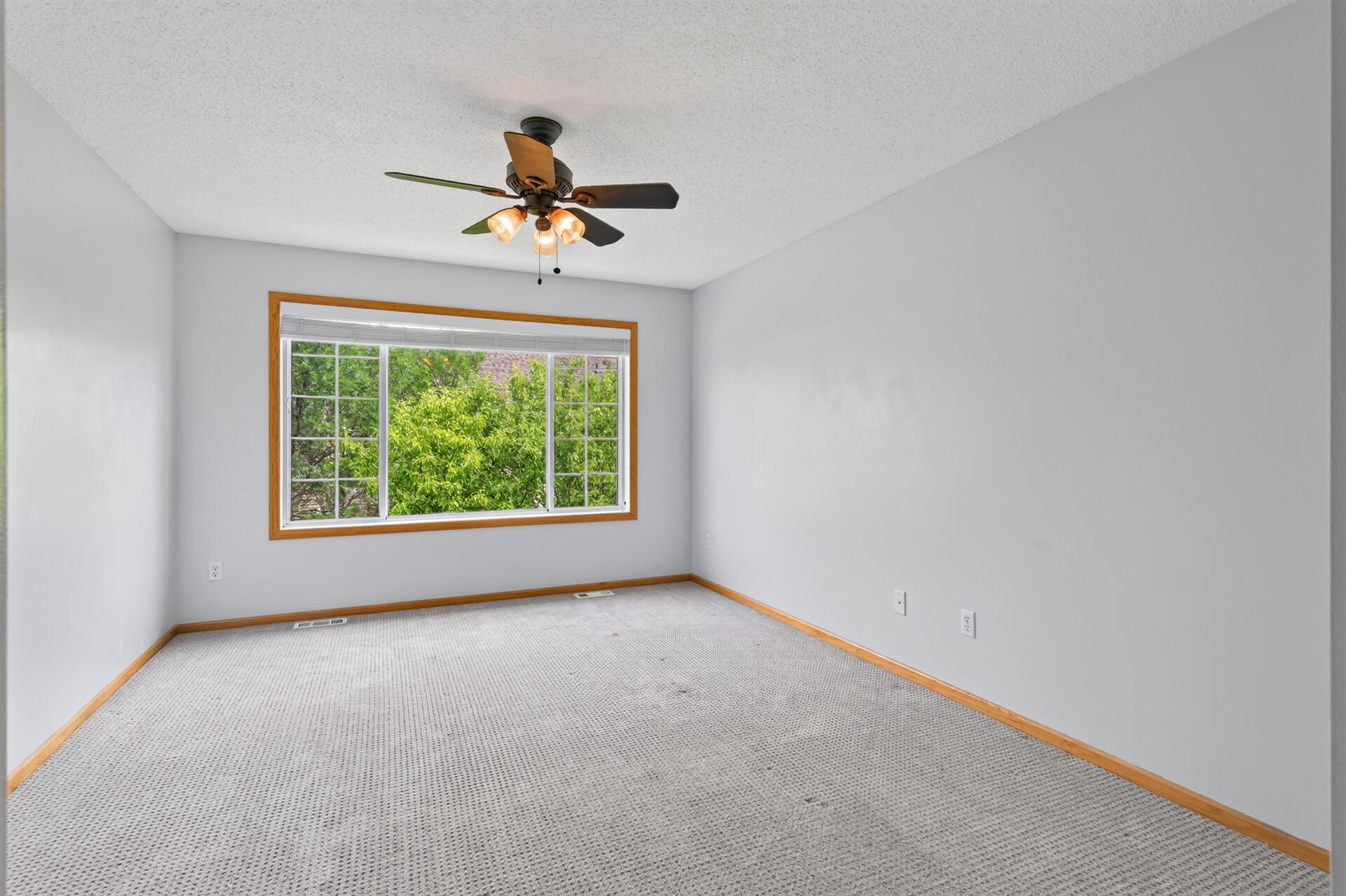Generous primary suite highlighted by an oversized window and abundant natural light.