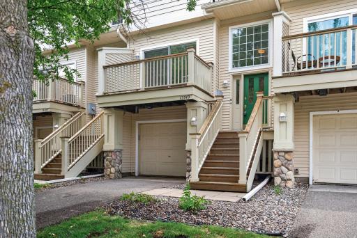 Front entry with private staircase, attached tandem-style garage, and peaceful setting.