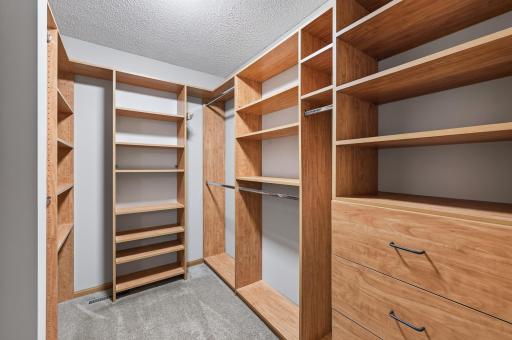 Custom shelving transforms this spacious walk-in closet into a beautifully organized space with room for everything.