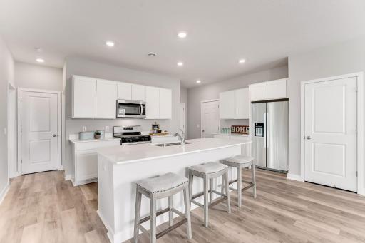 Truly, an open concept floorplan! *Photo is of a model home. Cabinets in the property for sale are grey.