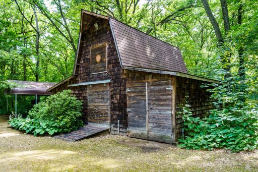 Picturesque outbuilding offers the perfect rustic aesthetic for a hobby workshop or extra storage space. Adjacent is a 23x26 carport with electricity run to it for more covered parking.