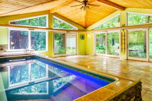 Includes a 20x23 pool sanctuary equipped with exercise/swim jets for a 'treadmill' swim workout experience or relaxing on the side seating. It is surrounded by walls of sliding glass doors and geometric transom windows.
