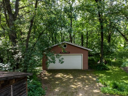 Spacious 24x29 detached garage featuring a wide overhead door, convenient side and back service doors, and matching siding that blends perfectly.