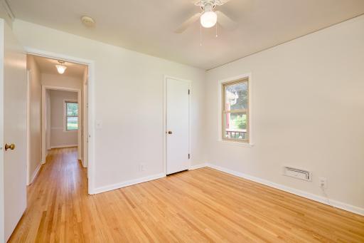 The main-floor bedroom is conveniently located. Looking down the hall, the first door on the left opens to the living room, while the first door on the right leads to the full bath, offering easy access for residents and guests alike.
