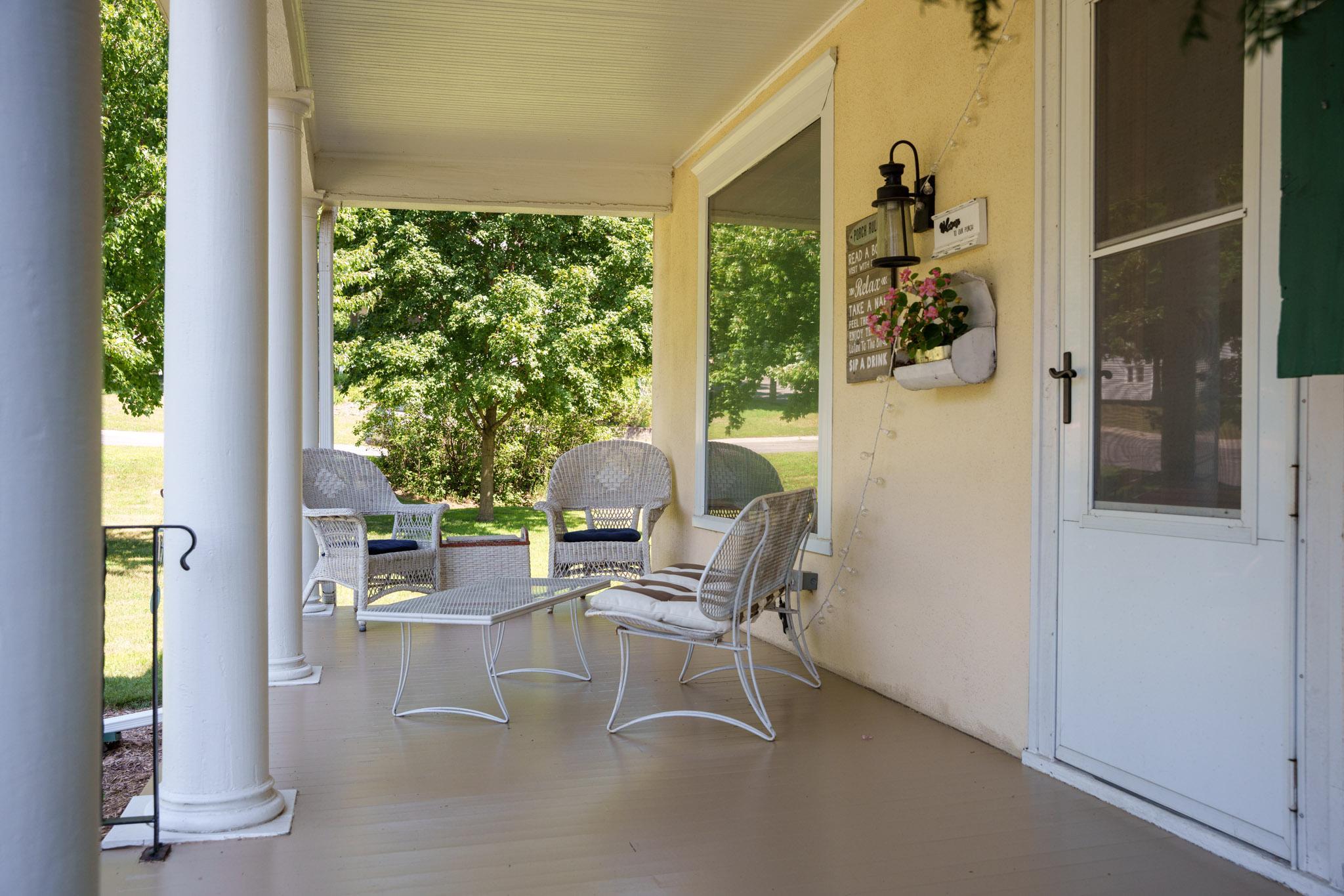 The spacious porch is a welcoming and wonderful place to sit with friends and family in the cool shade!