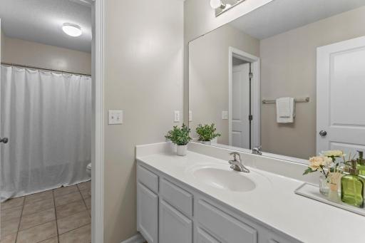 The shared full bathroom on the upper level features a split layout with extended counter space.