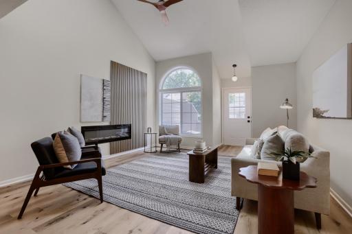 Living room with vaulted ceiling and fireplace.