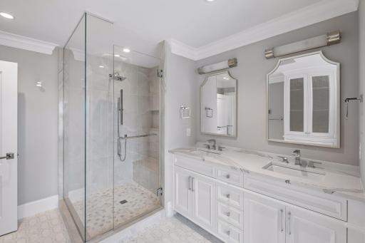 Primary bathroom features double sinks and dual vanities, walk-in shower, separate soaking tub, and access to the walk-in closet