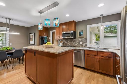 The kitchen features custom cabinets, two ovens, and granite countertops