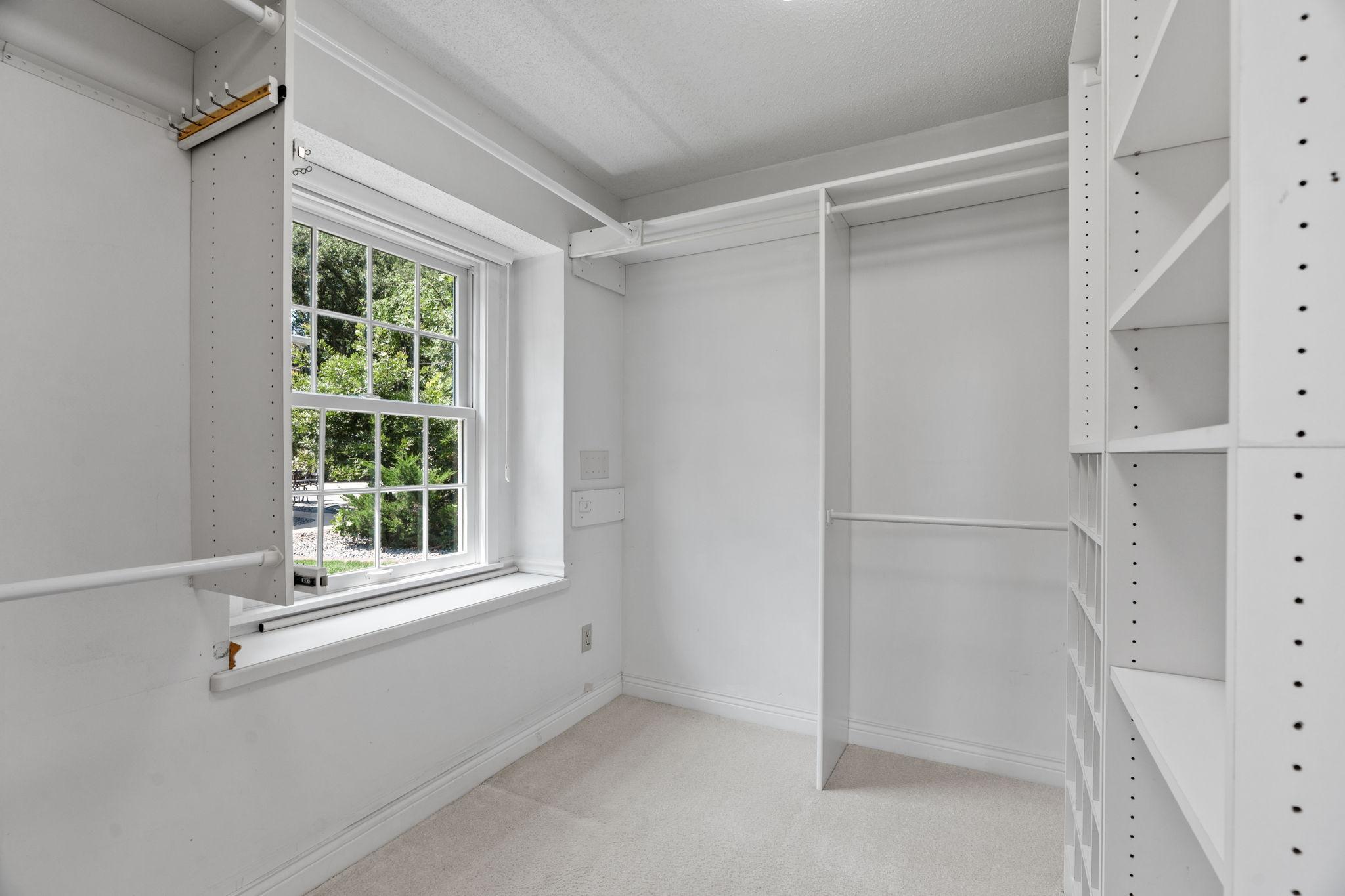 Primary walk in closet with built ins.