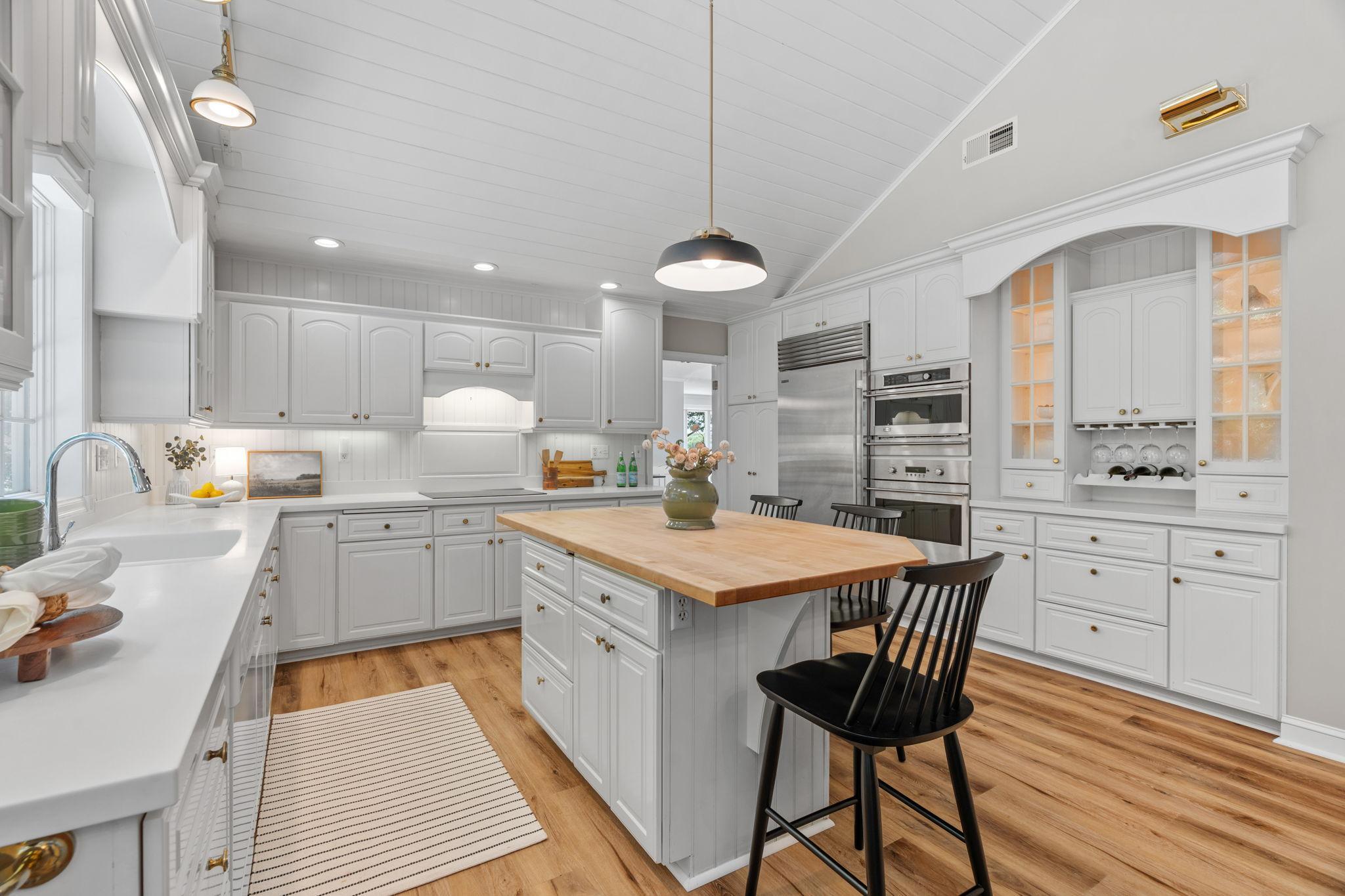 View of the kitchen - custom built-ins, stainless steel appliances, and under cabinet lighting.