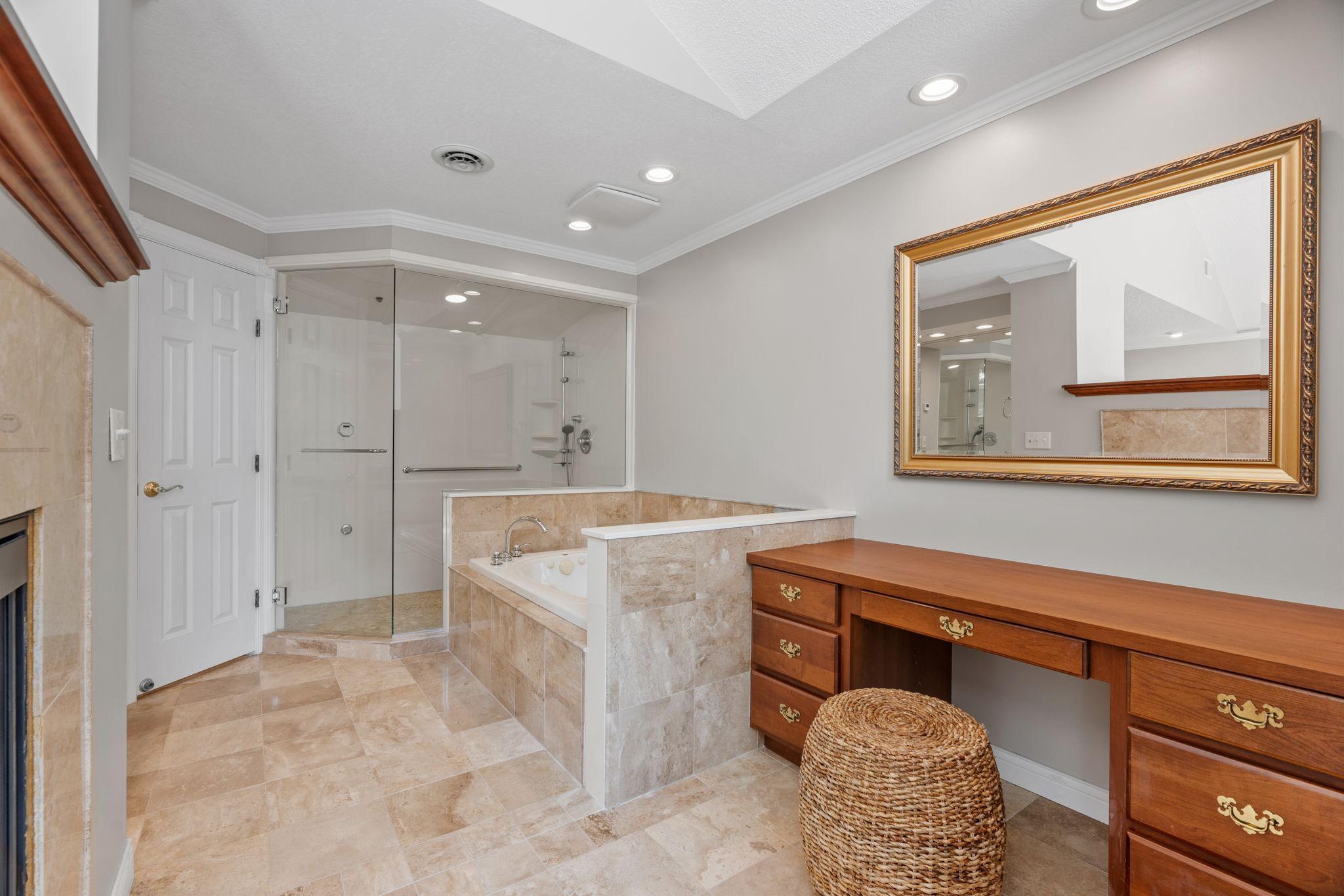 The private primary bath. Built in vanity area, sink in tub, and a steam shower