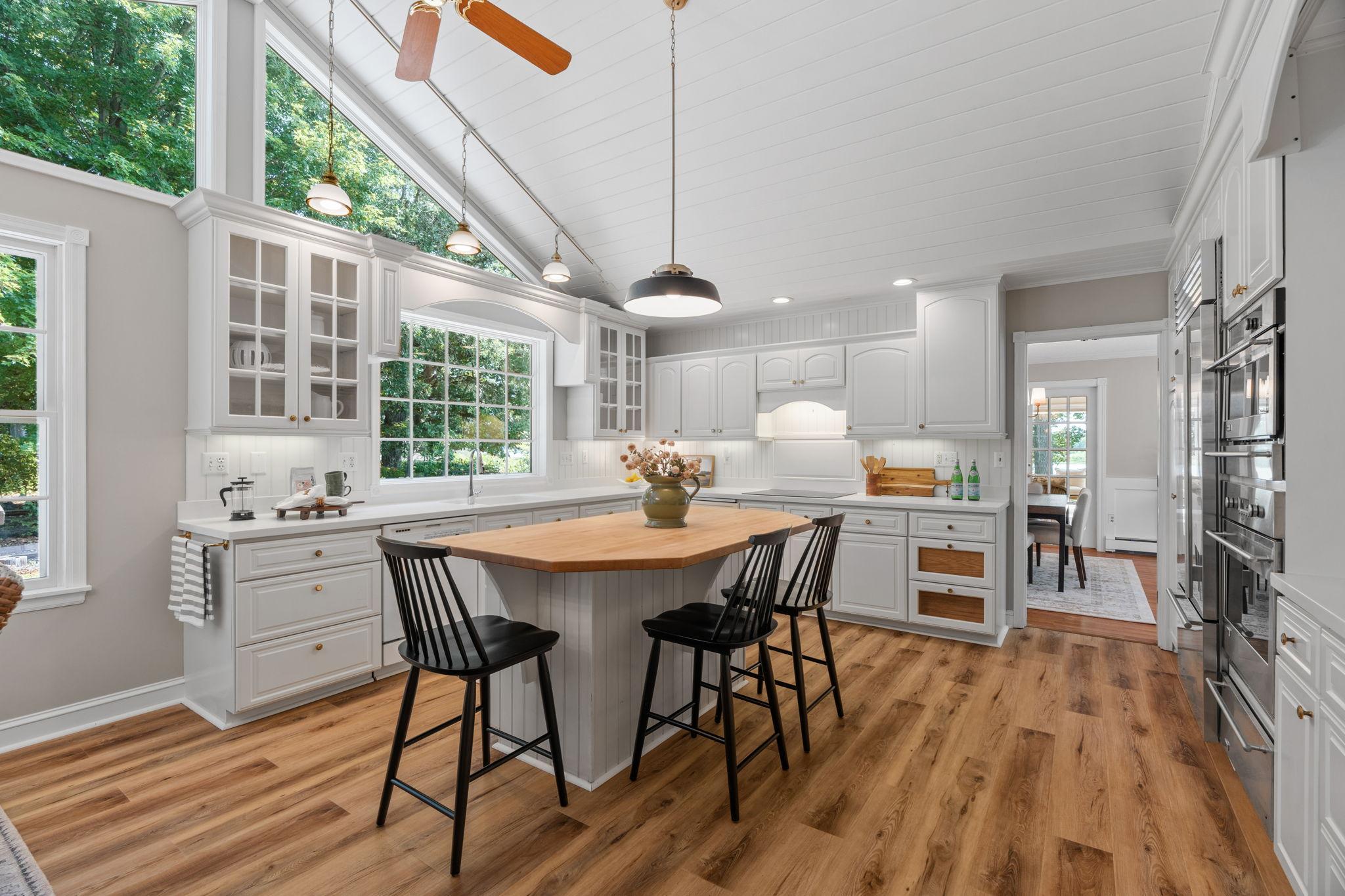 The center island provides additional seating. Wall ovens for preparing meals.