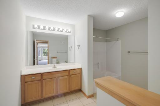 Upper-level full bathroom with ceramic floors and a bonus linen closet.