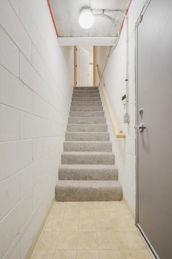 Carpeted stairs leading to the garage - there is a coat closet in this area which is great to not have to bring everything upstairs.