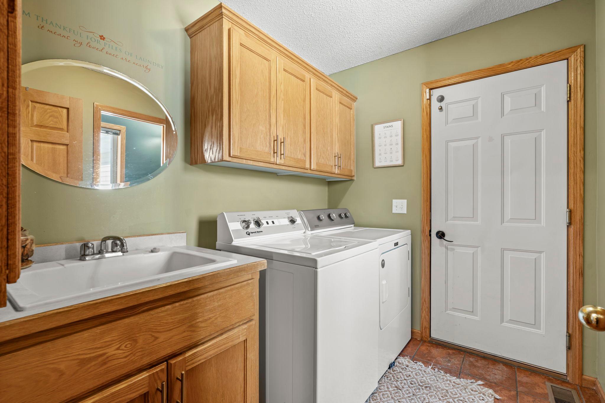 A main-level laundry room and mudroom keep daily life organized and stress-free.
