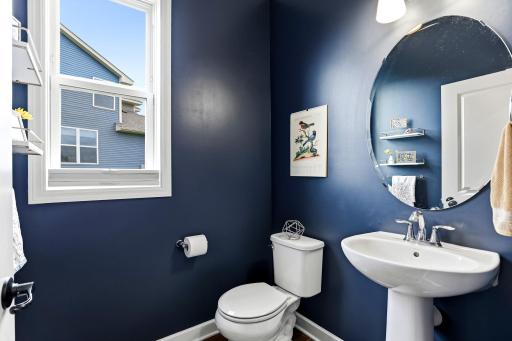 Deep navy walls and a classic pedestal sink give the powder room boutique-hotel personality.