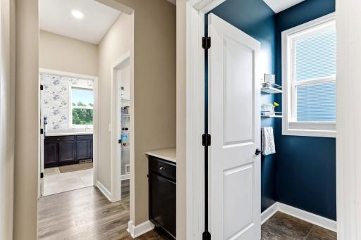 A convenient hallway hub adds extra counter and cabinet storage and pantry between the laundry and half bath.