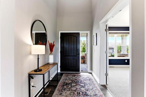 Soaring ceilings greet you in the foyer, where a rich wood door and long sightlines set the tone from the first step inside.