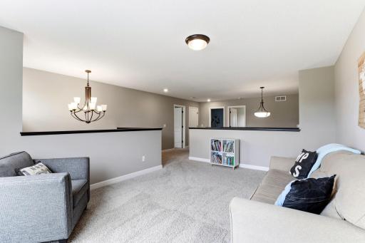 Generous enough for movie nights and game tables, the loft sits at the center of the upper level.