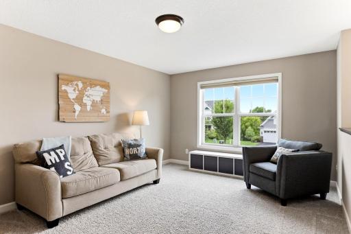 Upstairs, the loft delivers a second living room with a sunny window seat and storage tucked below.