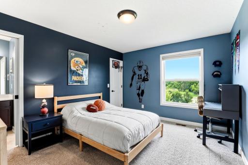 Sports fans settle in fast here, with bold blue walls and a wide window over the green space behind the home.