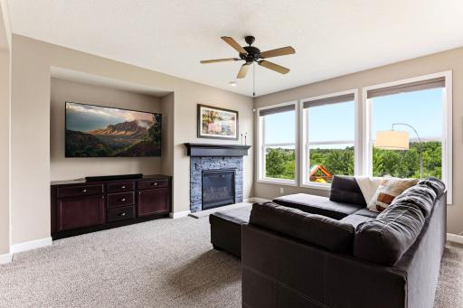 Sunlit and welcoming, the family room pairs its cozy fireplace with backyard views in every window.