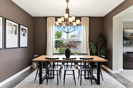 A statement chandelier and rich, moody walls give the dining room true dinner-party presence.