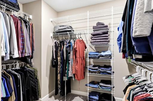 The primary walk-in closet handles two full wardrobes with room to spare.