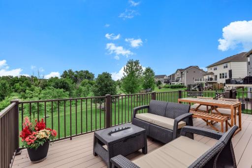 Panoramic views over open green space make the deck feel like a front-row seat to summer.