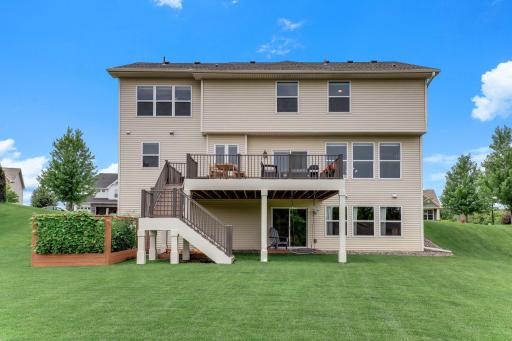 Deck stairs descend straight to the garden, patio, and play space, keeping indoor and outdoor living connected.