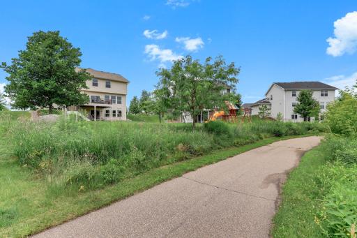 A paved trail runs directly behind the home, linking the neighborhood's parks and green space.
