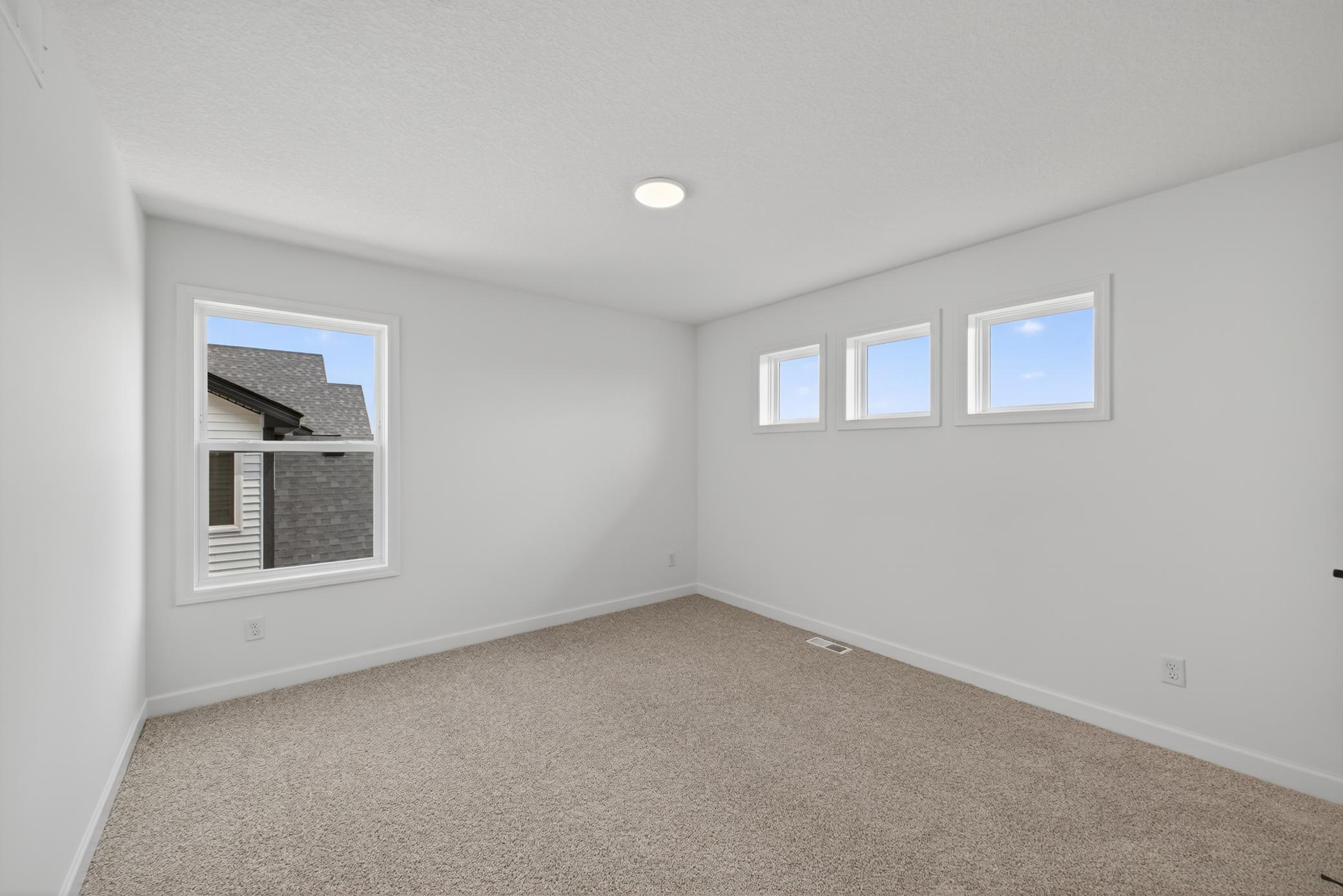 (Photo of a similar home, features will vary) One of three generously sized secondary bedrooms with spacious closets.