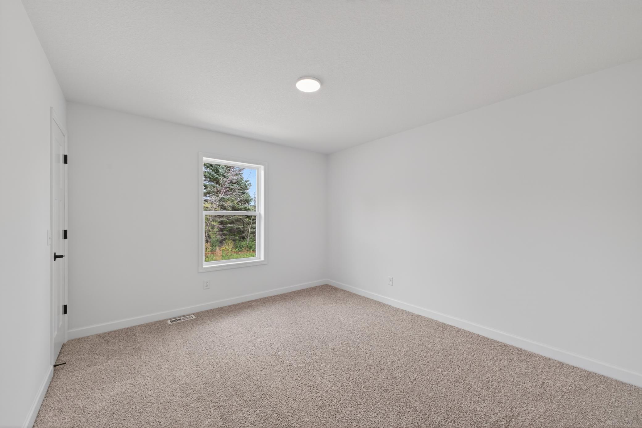 (Photo of a similar home, features will vary) One of three generously sized secondary bedrooms with spacious closets.