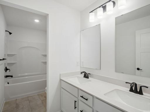 This full bathroom is conveniently located on the second floor and showcases dual sinks and a shower-tub combination.