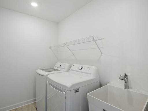 The laundry room will simplify chore days with an overhead shelf and washer-dryer connections.
