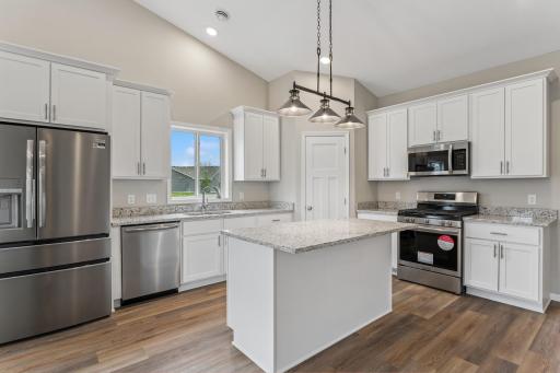 Well equipped and open Kitchen with walk-in pantry, island, soft close cabinetry, granite countertops and gorgeous luxury wide plank floors and vaulted ceilings.