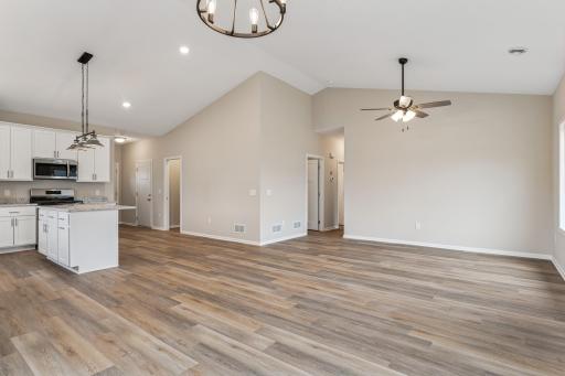 Beautiful open floor plan with walk-in pantry, island, soft close cabinetry, granite countertops and gorgeous luxury wide plank floors and vaulted ceilings.