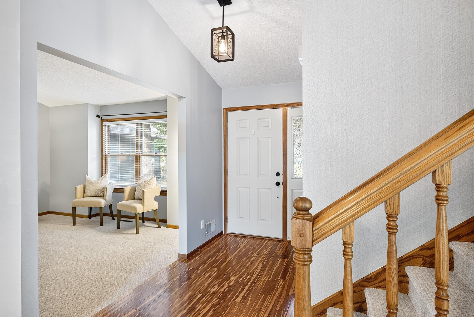 Main foyer with large flexible den/family room, coat closet, and stairs leading to second level.