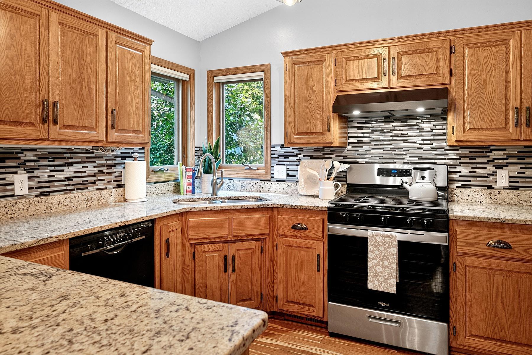 Granite countertops, natural wood cabinets, corner window, and stainless steel stove and refrigerator new in 2025.