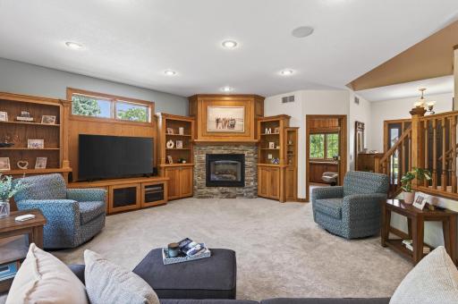Living room features a cozy gas fireplace, built-ins, and beautiful views of the backyard