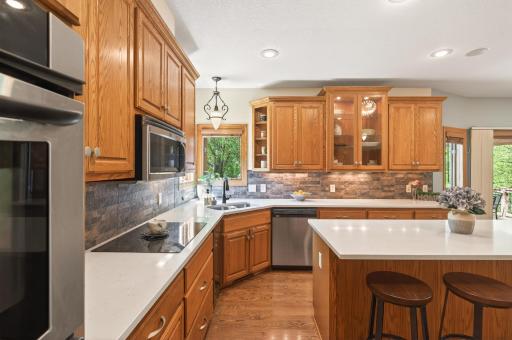 Chef's kitchen features large center island with counter seating, stainless steel appliances, a walk-in pantry and quartz countertops