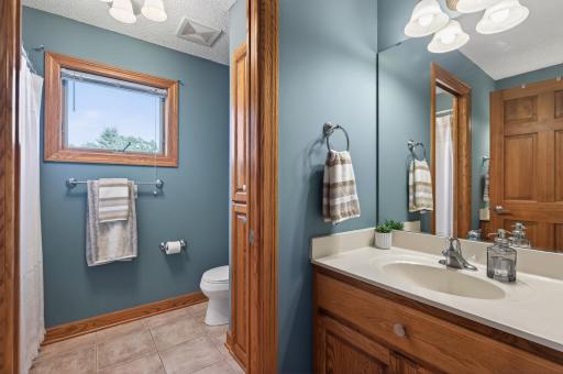 Upper level bathroom with thoughtfully-designed separation offered between the two vanities and the shower/toilet area