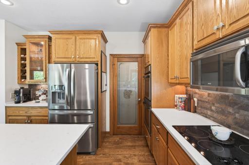 Chef's kitchen features large center island with counter seating, stainless steel appliances, a walk-in pantry and quartz countertops